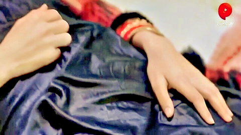 Indian woman's elegant hand with red bangles on silk sheets in Babuji Hindi web series