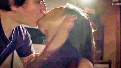 East Asian man passionately kissing Japanese brunette woman's lips while gripping her neck in steamy apartment.