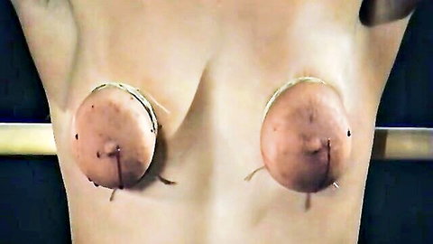 Woman's bound breasts in intense BDSM restraint, nipples clamped, arms raised