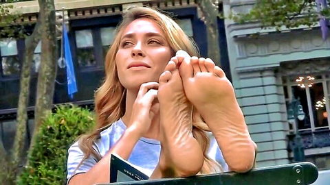 Blonde babe teases with bare foot soles and spread toes outdoors on bench