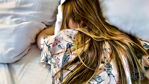Blonde stepmom in floral nightie lying seductively on hotel bed