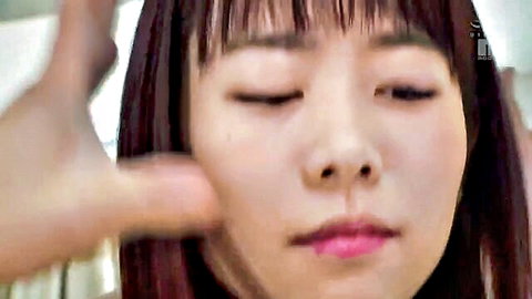 Cute Japanese girl with bangs has cheek pinched by hand in closeup tease