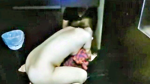 Pale naked woman bent over on floor with red anal toy inserted in her ass under table