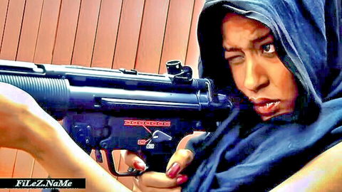 Hooded Asian woman intensely gripping black submachine gun with red nails
