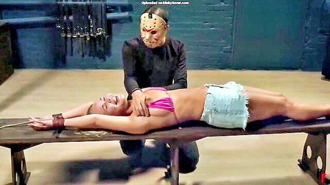 Jason masked man gropes bound blonde's tits over pink bikini in BDSM bondage on bench