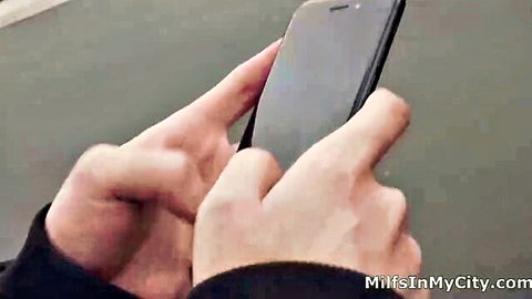 Man holding phone viewing Hot Milf Asks for Forgiveness with Her Pussy adult video