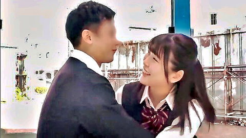 Smiling Japanese schoolgirl in uniform embraced by boy outdoors