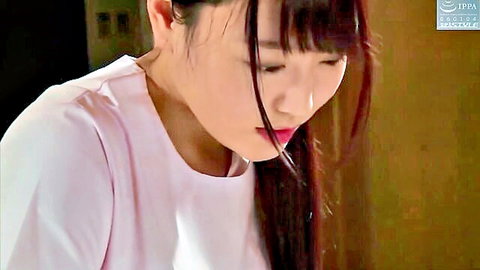 Young Japanese beauty with bangs gazes seductively in pink top closeup