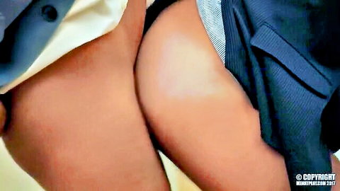 Tanned woman's bare juicy ass cheeks exposed with white skirt hiked up closeup