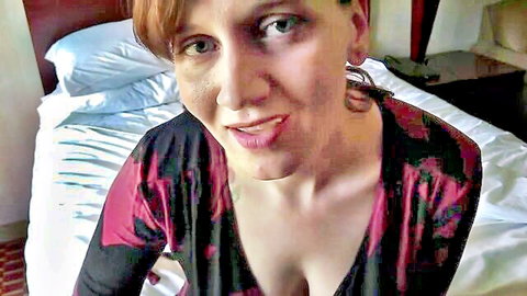 Redhead MILF teases with tongue out and big cleavage in low-cut dress POV