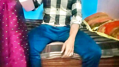 Indian couple in sari and plaid shirt teasing on colorful bed