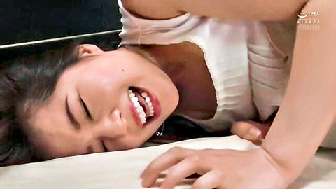 Young Japanese girl with small tits moaning in ecstasy topless on bed