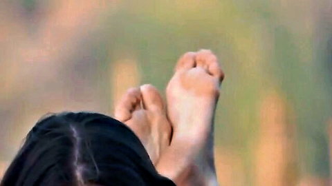 Candid close-up of bare Asian soles in BDSM pose, sexy foot fetish view