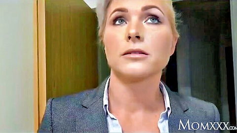 Blonde MILF in gray suit jacket and white shirt teases with seductive open mouth closeup