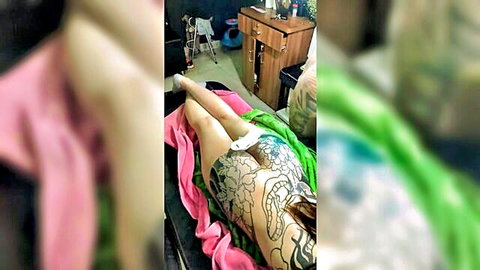Tattooed Asian woman exposing inked ass and pussy in pink panties