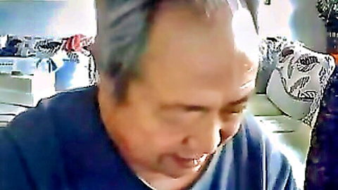Mature Asian man with gray hair smiling in casual shirt, old couple scene