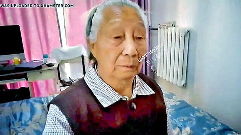 Elderly Chinese granny in casual vest and shirt, mature Asian woman close-up