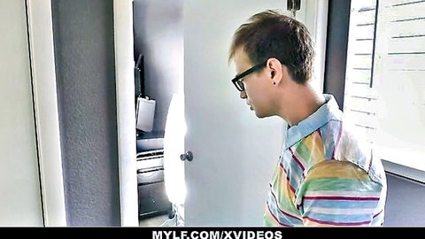 Skinny white guy with glasses in striped shirt peeking through bedroom door