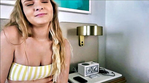 Blonde teen smiling seductively in yellow striped bandeau bikini top showing cleavage and underboob