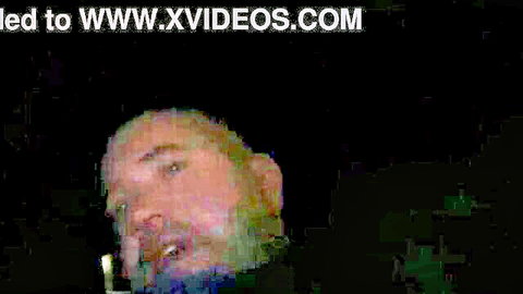 Close-up of bearded man with open mouth speaking intensely on black background