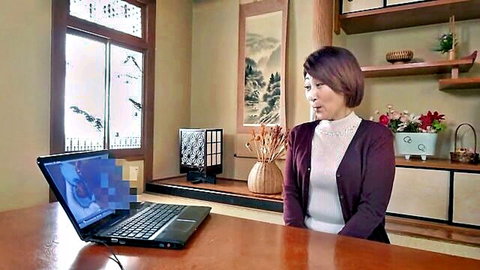 Mature Japanese woman in sweater sits at laptop in traditional room speaking openly
