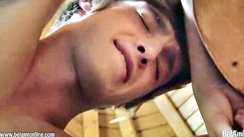 Ecstatic young gay twink with open mouth and closed eyes as hand holds wooden paddle near face