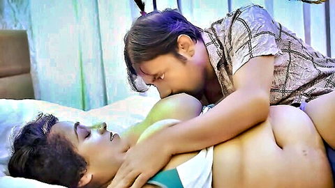 Man passionately sucking busty woman's exposed big tits in steamy bed scene