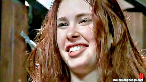 Jordan White redhead smiling in gangbang BDSM scene