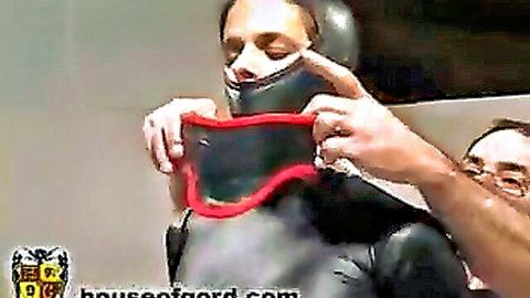BDSM slave in latex masked and gagged by dominant man