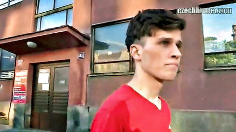 Young athletic Czech guy in red shirt outside urban building