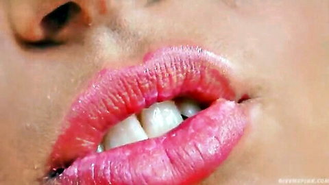 Closeup of sexy glossy pink lips parted wide showing teeth seductively