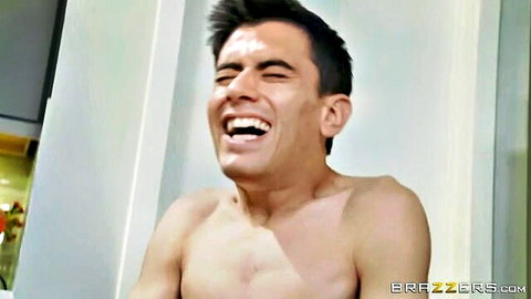 Shirtless muscular Latino hunk laughing wildly in kitchen during Brazzers porno scene