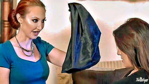 Redhead MILF in teal dress holds black lingerie over brunette babe's face in tease