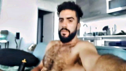 Hairy chested bearded muscular man shirtless selfie on couch
