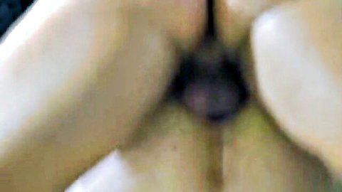 Pale woman's ass cheeks spread wide with dark purple toy inserted deep in her tight asshole