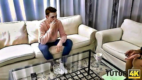 Mature woman in dress chats with young student on couch