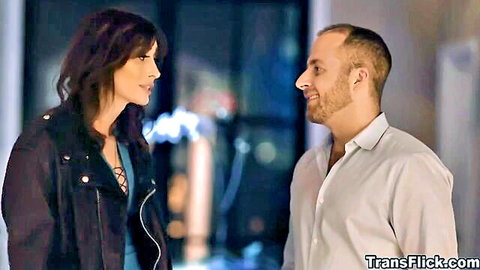 Brunette transwoman in leather jacket intimately faces bearded man
