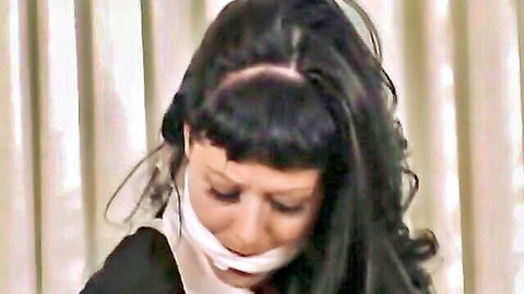 Bound brunette with tape gag in stockings BDSM scene