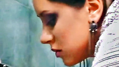 Seductive brunette's profile closeup in bathroom with smoky eyes and glossy lips