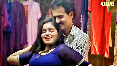 Indian MILF in blue saree blouse embraced by man in clothing store seduction scene