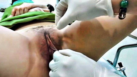 Close-up labiaplasty surgery on exposed female vagina with gloved hands