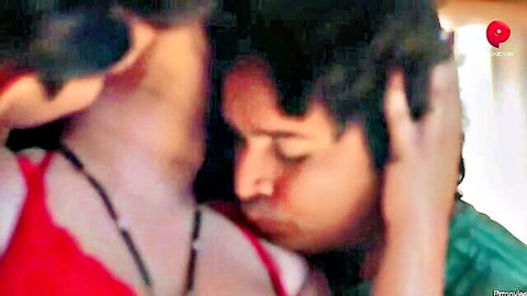 Indian couple in passionate neck kiss embrace, woman in red top