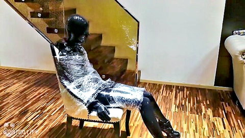 Chinese woman in black rubber bondage and plastic wrap BDSM pose