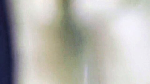 Blurry woman in shiny latex catsuit and ballet boots BDSM pose