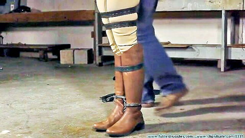 Belt-bound woman in boots dominated in BDSM scene