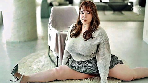 Nina Nishimura in low-cut gray sweater and short skirt, legs spread wide teasing J-cup cleavage