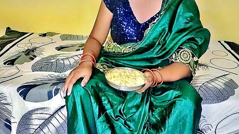 Desi woman in green saree holding bowl of milky food, sister-in-law feeding tease