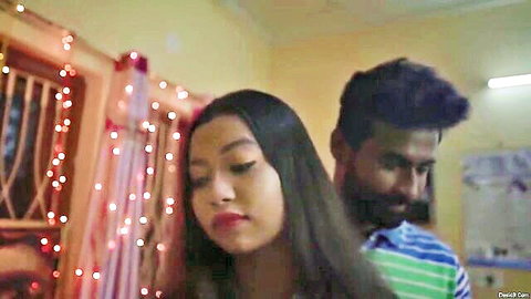 Indian couple in intimate embrace, woman with long dark hair looking back at man