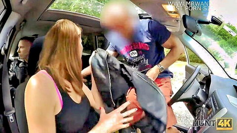 Brunette in pink top holds backpack close to bald black stranger in car with white guy watching
