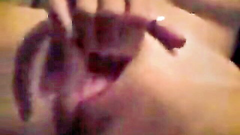 Woman spreads her wet pink pussy lips wide open with fingers in closeup